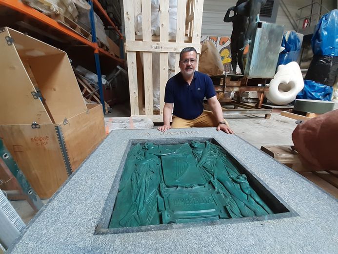 The director of Socra and the large granite and bronze plaque that will be attached to the base.