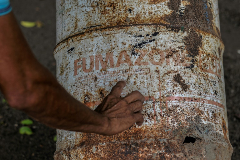Agricultural worker Pedro Fletes shows rusty cans, which contained the pesticide DBCP, on May 11, 2022 in Tonala, Nicaragua (AFP - )